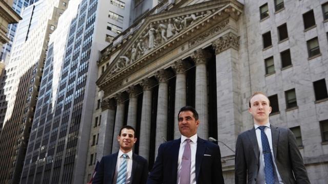 Three guys in front ofd Stock Exchange New York